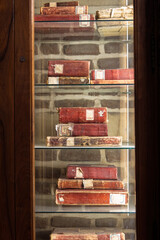 Antique red-bound books displayed in a wooden glass cabinet in Cairo library setting