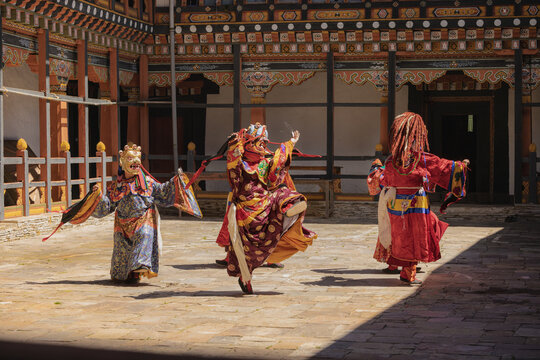 Jakar Dzong, Bhutan - 24 September 2025: View of dancers in traditional attire performing a vibrant, colourful dance against the backdrop of intricately decorated architecture.