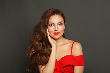 Fototapeta premium Fashionable woman with long hair and make-up on black background. Gorgeous woman with curly hairstyle