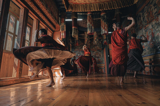 Jakar Dzong, Bhutan - 24 September 2025: View of monks in red robes dancing, their movements creating a vibrant spectacle of color and motion against the ancient walls.