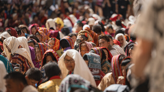 Thimphu, Bhutan - 28 September 2025: View of a sea of faces, each a unique portrait framed by traditional scarves and head coverings, bathed in the warm glow of a sunny afternoon at Tashichho Dzong.