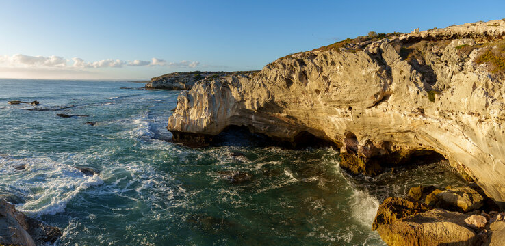 Dramatic coastline near Waenhuiskrans Cave, Arniston: towering cliffs meet ocean waves in pristine Overberg seascape, Western Cape, South Africa. Ideal for nature, travel, and adventure visuals.