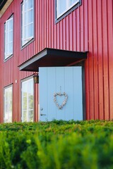 Cozy wooden house entrance with blue door and heart decoration