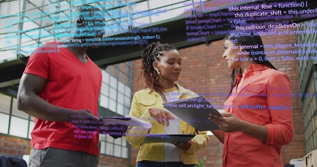 Discussing trio in red yellow coral shirts reviewing tablets, documents in loft with code overlay