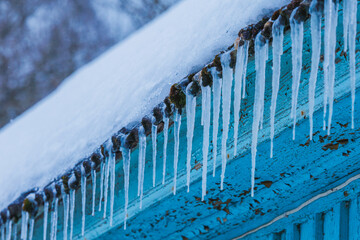 Icicles on the roof of the house. Danger of falling
