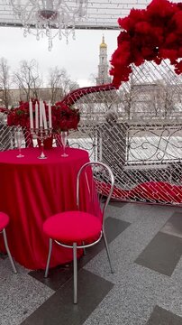A table with a red tablecloth on the embankment