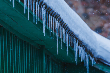 Icicles on the roof of the house. Danger of falling