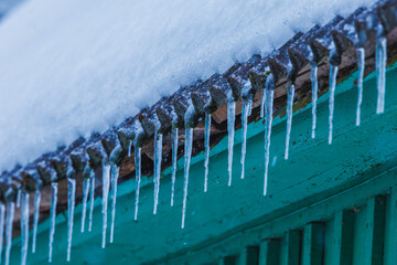 Icicles on the roof of the house. Danger of falling