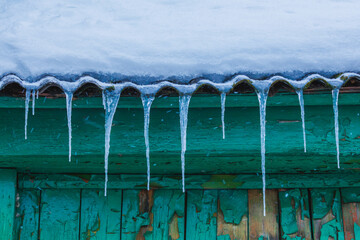 Icicles on the roof of the house. Danger of falling