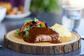Fototapeta premium Gourmet Meal: An enticing close-up of a perfectly plated gourmet meal featuring a succulent steak, served with a rich sauce.