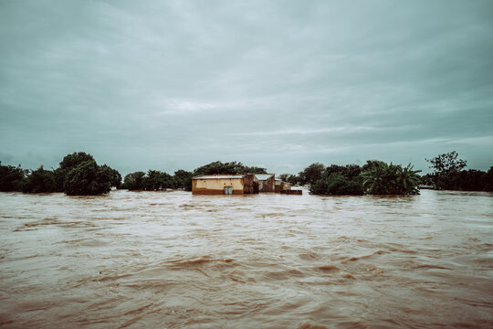 Manhica, Mozambique - 20 January 2026: View of a building nearly submerged, surrounded by murky floodwaters reflecting the overcast skies, a stark reminder of nature's power.
