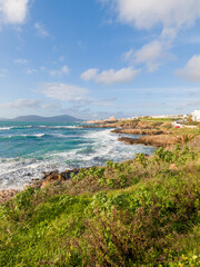 Rough Sea Along the Coast of Alghero Under a Blue Sky with White Clouds