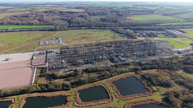 The Great Grid Upgrade aerial view of Sundon Supergrid substation near Luton UK featuring 400kV transformers and high-voltage pylons.