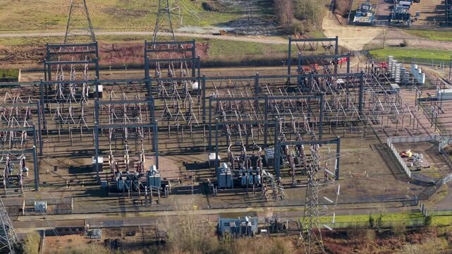 The Great Grid Upgrade aerial view of Sundon Supergrid substation near Luton UK featuring 400kV transformers and high-voltage pylons.