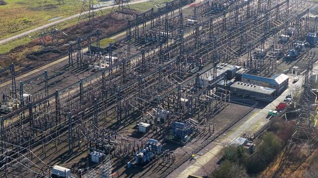 The Great Grid Upgrade aerial view of Sundon Supergrid substation near Luton UK featuring 400kV transformers and high-voltage pylons.