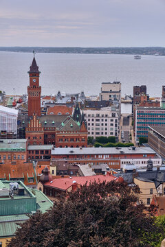 Helsingborg, Sweden - 12 August 2025: View of the red-brick Helsingborg City Hall tower piercing the skyline, overlooking the serene waters of the strait and surrounding buildings.