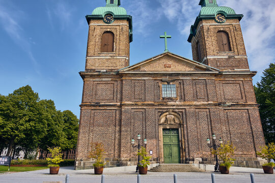 Landskrona, Sweden - 08 August 2025: View of the Church of Sofia Albertina stands majestically, its brick facade catching the sunlight, contrasting against the clear blue sky and lush green trees.