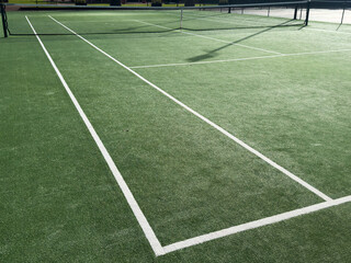 Green tennis court that is empty