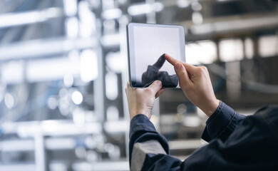 Concept food industry banner. Factory worker inspecting production line tanker in of dairy factory with computer tablet