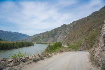 Mountain road running along the Katun river in Altai Russia. Scenic route winding through natural landscapes of the Altai mountains.