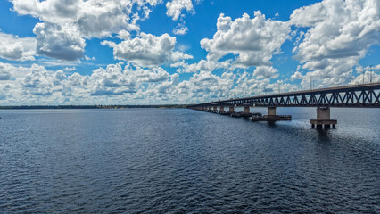 Obraz premium A large bridge spans across a body of water under a blue sky with white clouds