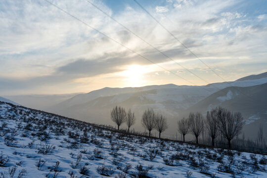 Winter Sunset Over Snow Covered Rural Mountain Landscape in Uzbekistan