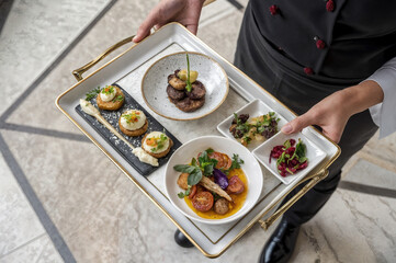two hands holding a tray of food