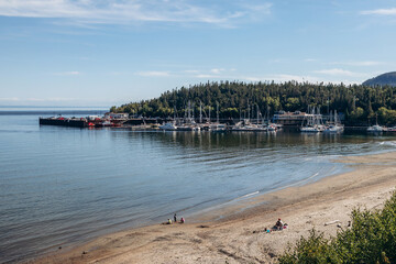Obraz premium Tadoussac, Canada - August 22, 2025: Panoramic view of Tadoussac marina and sandy beach along the St Lawrence River