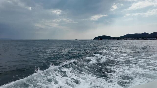 ferry departing from Koh Lan (Ko Lan) island, ocean view, cloudy sky, boat wake