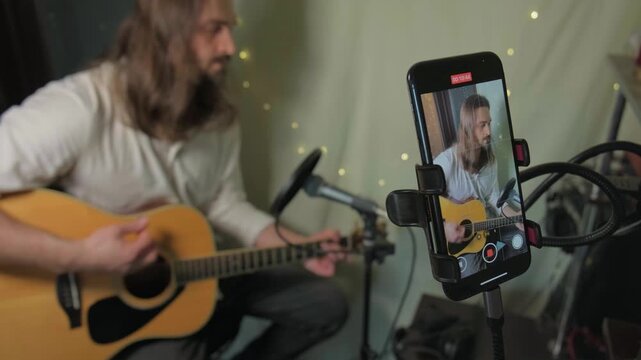 Home guitarist performing intimate unplugged session. Indie artist sharing authentic live music on social media, inviting viewers to virtual concert. Songwriter, online acoustic guitar workshop