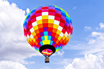 Fototapeta premium Colorful hot air balloon flying over blue sky with white clouds