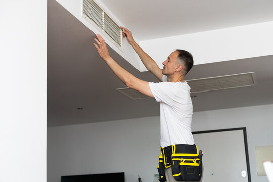  HVAC Technician Worker Testing Newly Installed Ventilation System. Commercial Heating, Cooling and Air Ventilation Systems.