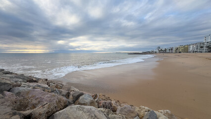 What a sandy beach on the Atlantic. Landscape shot at sunset of a coast with sandstone cliffs. Low tide on the yellow beach of Praia near Albufeira, Algarve, Portugal