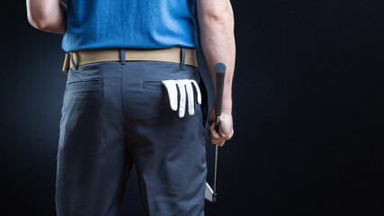 Golfer rear view with golf glove in back pocket and club in hand