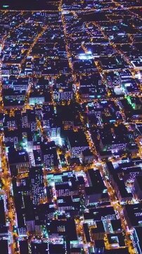 aerial night city grid glowing streets and intersections, golden arteries of traffic weaving through dark blocks, sensorlike neon highlights, drone survey and traffic analysis perspective with digital