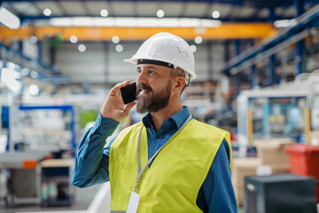 A portrait of project manager or engineer factory, making phone call.