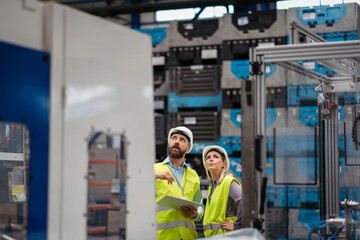 Industrial team analyzing data in high tech manufacturing plant.