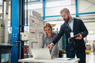 Industrial team analyzing data in high tech manufacturing plant.