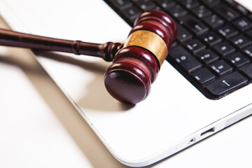 Wooden judge gavel on laptop keyboard. Law and justice concept.