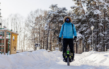 Person riding electric unicycle monowheel self-balancing personal transportation device on snowy winter terrain showing alternative eco-friendly urban mobility technology outdoor recreation activity © MarijaBazarova
