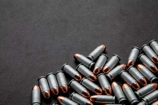 Pile of silver bullets on black background