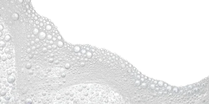 A close-up view of light gray bubbles forming a wave pattern on a high-key white background