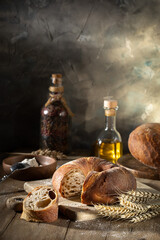 Fresh wheat bread and ears of wheat on a rustic table