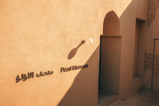 3 December 2025, Bahrain, Manama: Pearl Museum sign on a textured, traditional wall Muharraq district along Pearling Path trail
