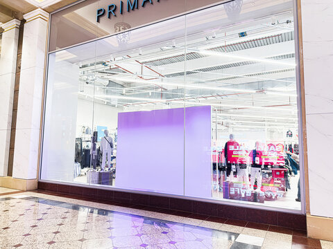 Shoppers Primark enter a Primark store at The Trafford Centre in Manchester with bold purple display and bright interior