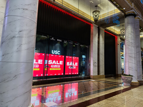 Sale USC signs glow in a luxury storefront at The Trafford Centre, Manchester, UK