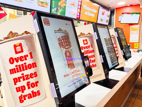 Busy Burger King self serve kiosks at the Trafford Centre Manchester promoting prizes and burgers