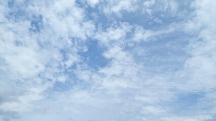Obraz premium Clear blue sky with beautiful white clouds. Blue sky background featuring bright clouds. The sky appears full of soft fluffy clouds.