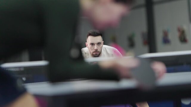 Focused male athlete playing intense table tennis match
