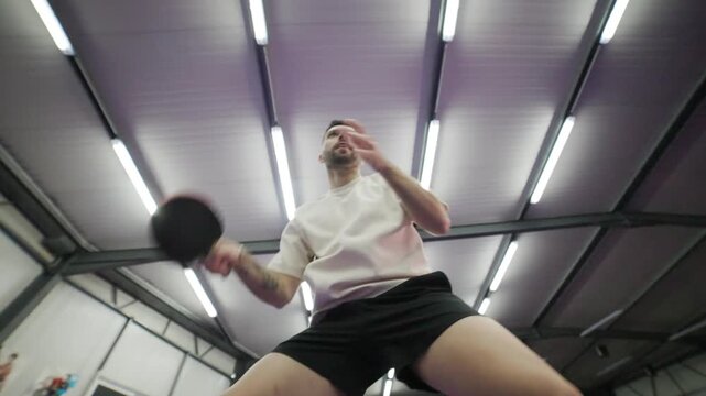 Low angle view of man playing table tennis with vigor
